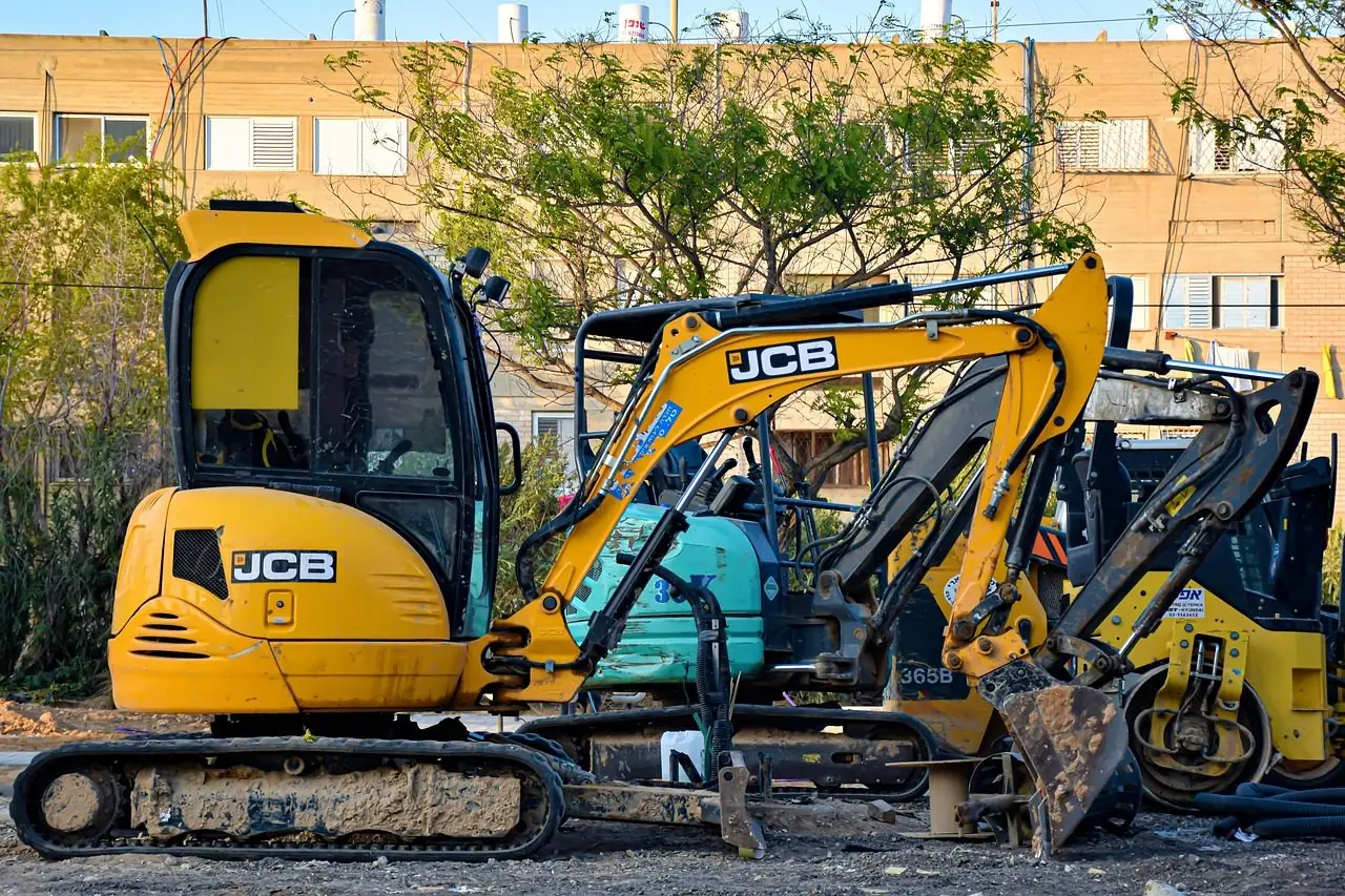 Row of compact excavators parked on a work site